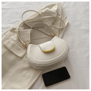 Detailed close-up of cream-white moon-shaped hobo bag with gold curved metal clasp