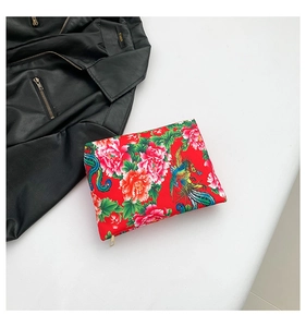 Close-up of ethnic nylon handbag featuring red peony and phoenix embroidery and gold zipper