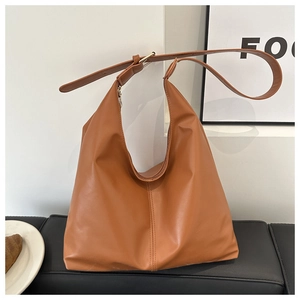 Detail view of large brown hobo bag with adjustable strap and decorative vertical stitching