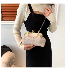Detail of vintage beige floral jacquard doctor bag with golden kiss-lock and metal chain