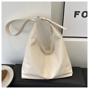 Close-up of minimalist cream white leather tote bag with stylish vertical stitching detail