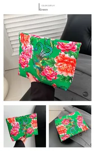 Close-up of green nylon clutch bag with traditional Chinese Phoenix and Peony floral pattern