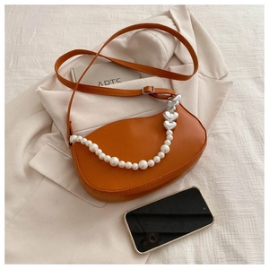 Détail du sac demi-lune orange avec chaîne en perles et perles en métal en forme de cœur