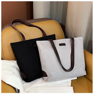 Detail view of durable canvas tote bags with premium leather straps and fashion label