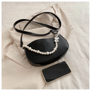 Détail du sac demi-lune noir avec chaîne en perles et cœurs et bandoulière réglable