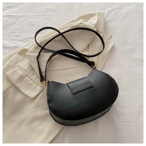Detail of black semi-circle PU leather bag with magnetic buckle and golden hardware