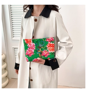 Detail of emerald green nylon clutch featuring traditional Chinese phoenix and peony patterns