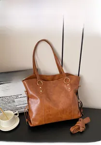 Detail view of brown large tote bag with polished PU leather and gold ring hardware