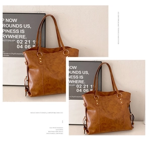 Detail view of large brown tote bag with vintage wax texture and metal ring handles