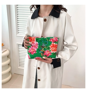 Detailed close-up of a nylon clutch bag featuring traditional phoenix and floral prints
