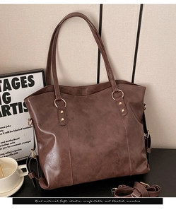 Detail of vintage brown tote bag texture with golden rings and detachable shoulder strap