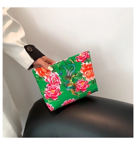 Detail of green floral nylon clutch featuring traditional Chinese peony and phoenix print