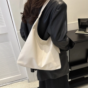 Minimalist ivory leather tote bag for women showing spacious bucket shape and soft texture