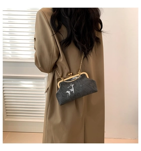 Detailed view of grey fabric crossbody bag featuring white deer print and golden clasp