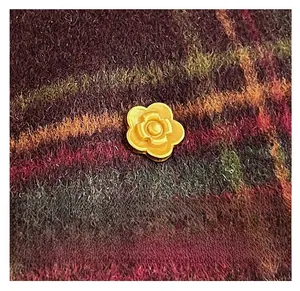 Close-up of golden petal-shaped metal hardware on vintage plaid woolen tote bag
