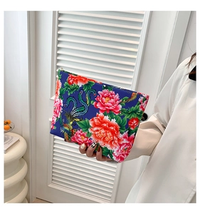 Detail of ethnic nylon clutch with vibrant blue peony and phoenix floral prints