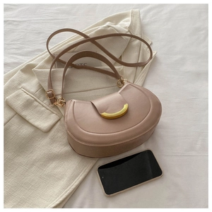 Detail of dusty pink half-moon shoulder bag with sleek curved gold metal hardware clasp