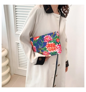 Ethnic nylon floral clutch with red peony and phoenix patterns shown on white coat