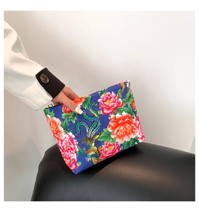 Detailed shot of ethnic nylon pouch featuring colorful peony flowers and phoenix patterns