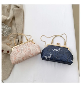 Close-up of retro floral embroidery on two vintage-style clasp bags with gold handles