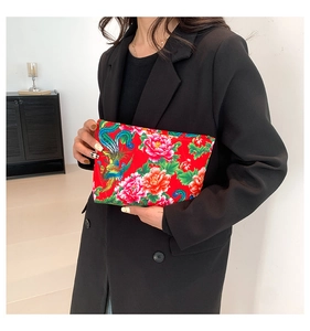 Ethnic nylon clutch bag with traditional red peony and phoenix prints in hand
