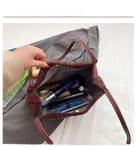 Detail view of plaid tote bag interior showing capacity for tablets and cosmetics