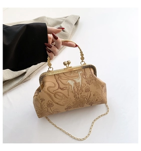 Detail of vintage clasp handbag with deer and floral print and golden carved handle