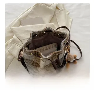Détail de l'intérieur du sac seau en peluche montrant la capacité pour téléphone et porte-monnaie