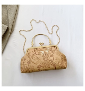 Detail of vintage jacquard fabric with golden deer patterns and ornate metal handle