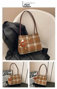 Detail of yellow plaid woolen tote bag featuring brown leather straps and plush charm