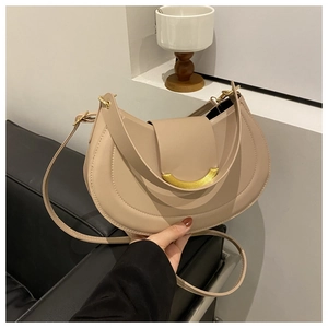 Detail of beige crescent handbag showing smooth leather texture and golden metal buckle