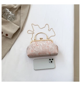 Flat lay of retro floral jacquard frame bag with golden chain and deer pattern
