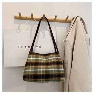 Detail of vintage plaid tote bag featuring fuzzy wool texture and golden flower hardware
