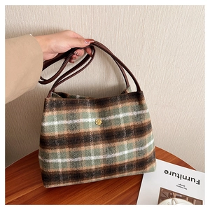 Detail of classic plaid wool tote bag featuring a golden flower metal clasp buckle