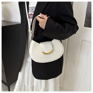Detailed shot of white half-moon shoulder bag with golden buckle on a model's outfit