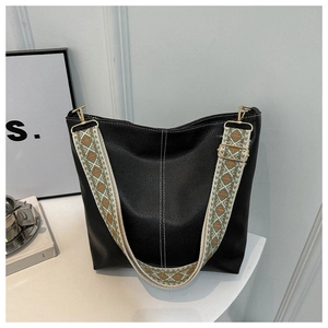 Detail of black lychee grain leather tote with embroidered geometric shoulder strap