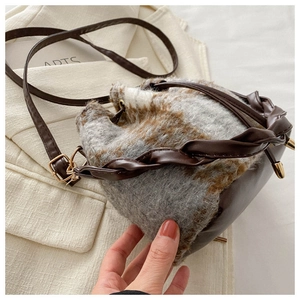 Détail du sac seau à carreaux en peluche avec poignée en cuir sur blazer beige