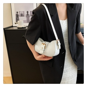 Chic white crescent shoulder bag with golden buckle shown in a modern fashion setting