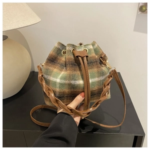 Détail du sac seau à carreaux verts avec poignée tissée et fermeture à cordon marron