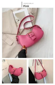Close-up of pink leather underarm bag featuring a stylish metal adjustment buckle strap