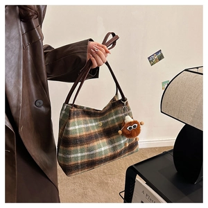 Detailed view of retro plaid tote bag with leather strap and plush charm
