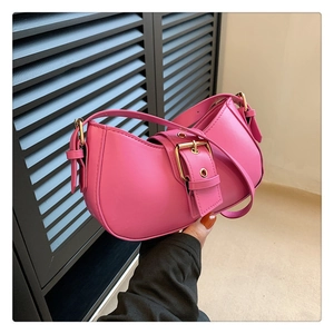 Detail of fuchsia half-moon bag featuring elegant golden square buckle and smooth finish