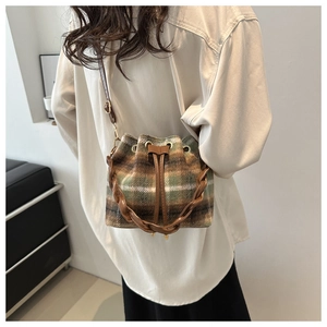Détail du sac seau à carreaux avec sangle décorative tissée et cordon de serrage en cuir
