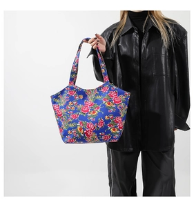 Detailansicht der großen Tote-Tasche mit lebhaftem Blumenmuster auf dunkelblauem Nylon