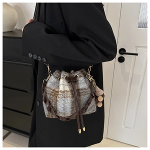 Vue détaillée du sac seau à carreaux avec texture peluche et cordon de serrage en cuir