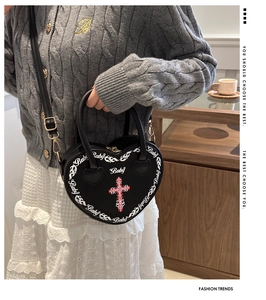 Close-up of black heart-shaped handbag with cross and Baby pattern for women
