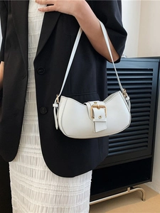 Minimalist white crescent underarm bag with gold buckle on a black suit model