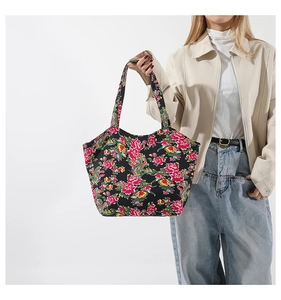 Detailaufnahme einer großen schwarzen Canvas-Tragetasche mit bunten Blumenmustern