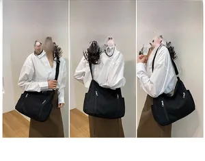 Détail du sac cabas noir polyvalent avec deux poches avant et bandoulière réglable
