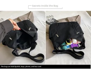 Détail de la capacité intérieure du sac bandoulière noir avec téléphone et parapluie